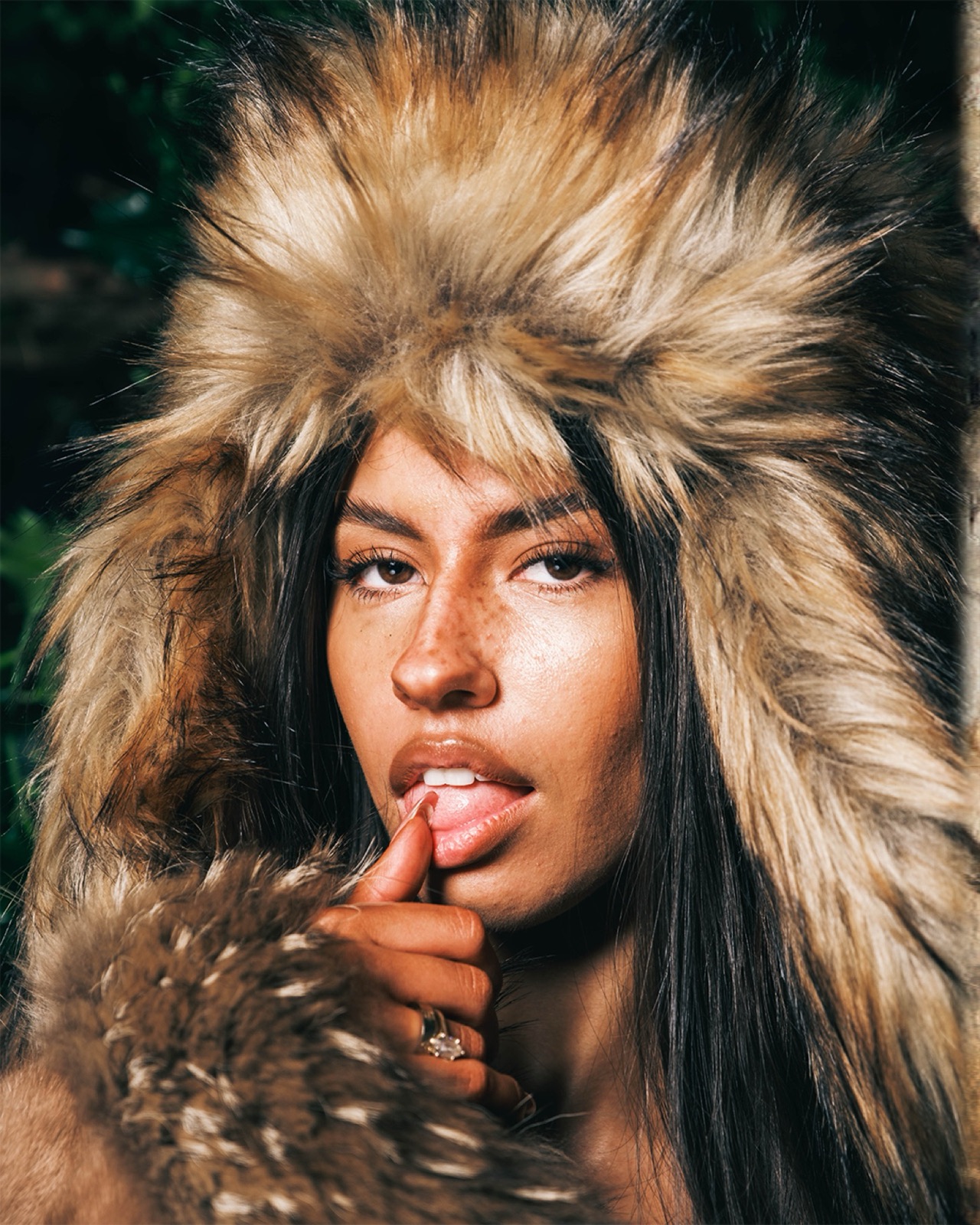 Close portrait framed by a hood with fur trim.